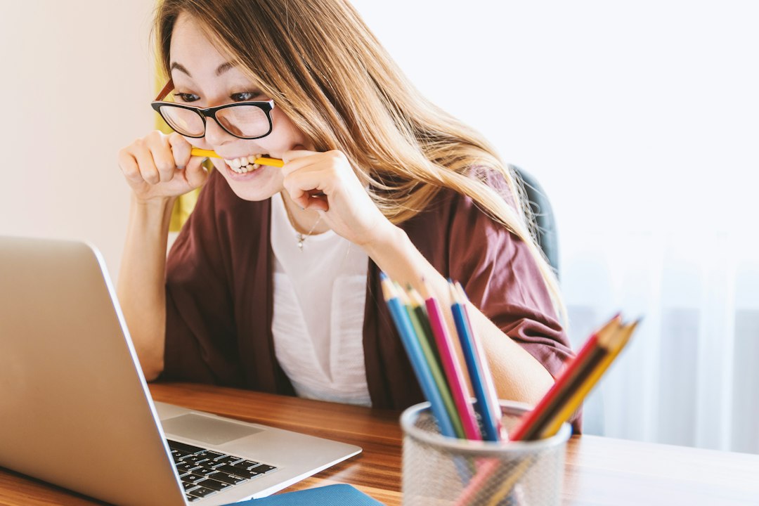 Student thinking while studying with a laptop and notebook