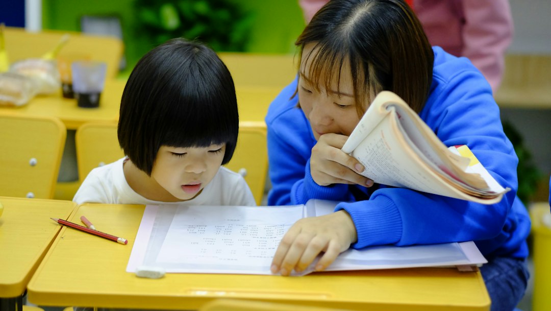 Woman helping a girl with a learning activity